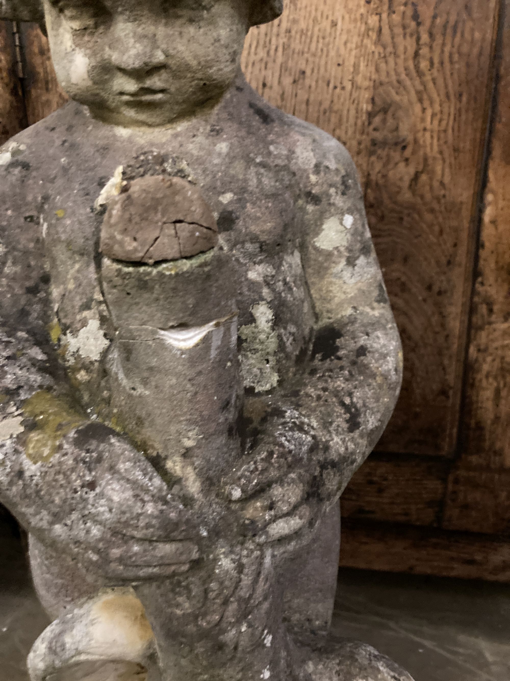 A reconstituted stone garden ornament of a putto with swan, height 68cm